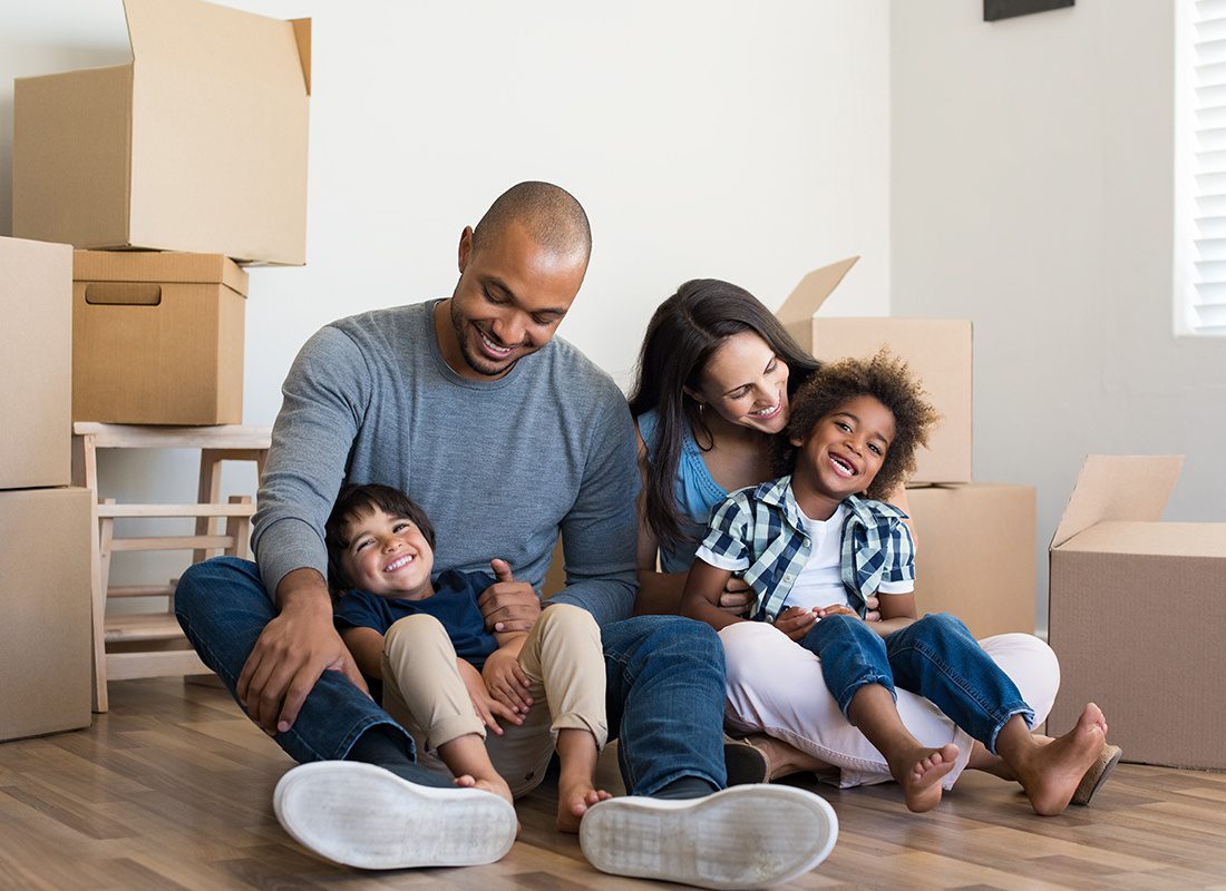 Personal Insurance - Happy Family Sitting Together in New Home With Moving Boxes